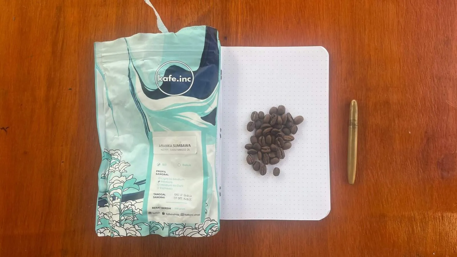 Rich, aromatic Arabica Sumbawa coffee beans from Barnaby Robson, displayed on a notepad with a gold pen for a sophisticated coffee experience. Perfect for coffee enthusiasts and connoisseurs.